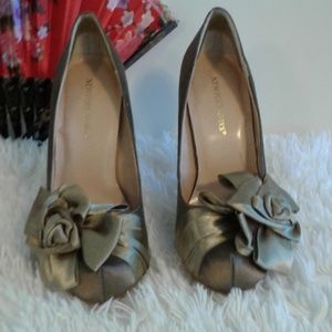Gold high heeled satin shoe with rosette on front